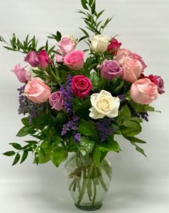 A beautiful assortment of colored roses and hydrangea inspired by our romance collection. Lavender, pinks, and purples. Modern design in a glass cylinder.