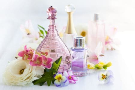 Perfume and aromatic oils bottles surrounded by fresh flower